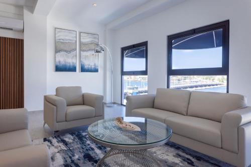 a living room with two couches and a glass table at Handelskade Penthouse in Willemstad