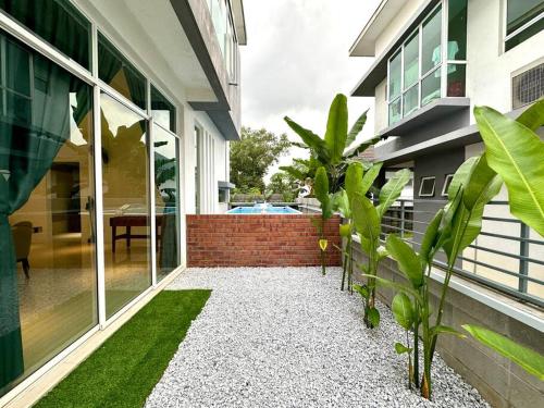 ラワンにあるBNB Luxe Homestay, Rawang - pool, 18 paxの植物が目の前に広がる中庭のある家