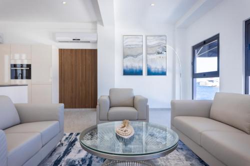 a living room with two couches and a glass table at Handelskade Penthouse in Willemstad