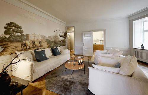 a living room with white couches and a table at ApartmentInCopenhagen Apartment 1569 in Copenhagen