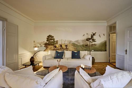 a living room with white couches and a painting on the wall at ApartmentInCopenhagen Apartment 1569 in Copenhagen