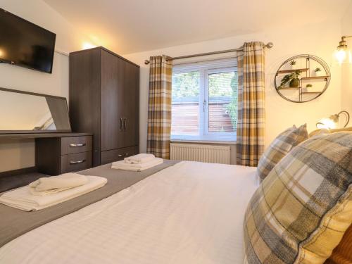 sypialnia z dużym łóżkiem i lustrem w obiekcie Puddleduck Lodge w mieście Windermere