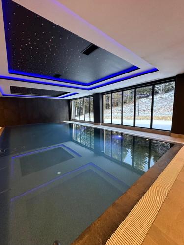 a swimming pool with blue lights in a house at Apartman Viktor 302 - Zlatni Javor in Jahorina