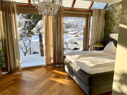 ein Schlafzimmer mit einem Bett und einem großen Fenster in der Unterkunft VILLA OXA in Maria Alm am Steinernen Meer