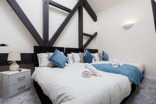 two beds in a bedroom with blue and white at Large Duplex Penthouse Apartment in Bradford