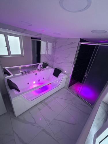 a large bathroom with a tub with purple lighting at LUIGI LUXURY SUITE in Naples