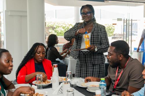a group of people sitting around a table eating at Beauty Hotel in Accra