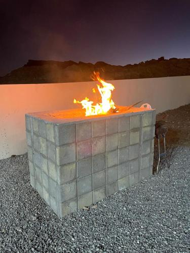 a fire pit sitting on the side of a wall at Jabal Shams, the summit house in Misfāh