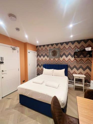 ein Schlafzimmer mit einem großen Bett und einer Wand in der Unterkunft Rainbow Radiance Studio Near brighton station in Brighton & Hove