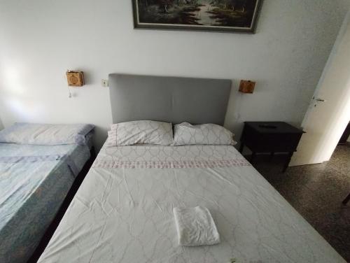 um pequeno quarto com 2 camas e uma mesa em Hotel eden em Bahía Blanca