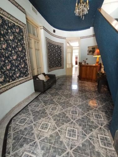 sala de estar con alfombra en la pared y sofá en Hotel eden en Bahía Blanca