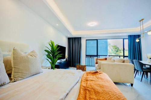 a bedroom with a large bed and a living room at Luxury studio apartment near Kigali Convention Center in Kigali