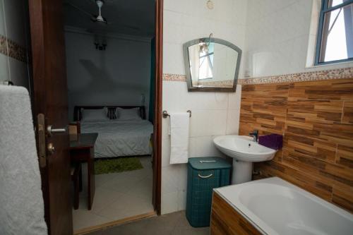 a bathroom with a sink and a bed at Beauty Hotel in Accra