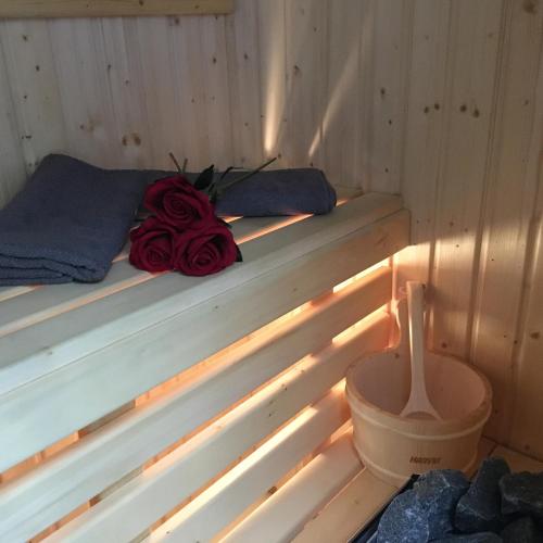 a bed in a sauna with a rose on it at Family & Business Sauna Apartments No 6 Leśny nad Zalewem Cedzyna - 1 Bedroom with Private Sauna, Terrace, Parking, Catering Options in Kielce