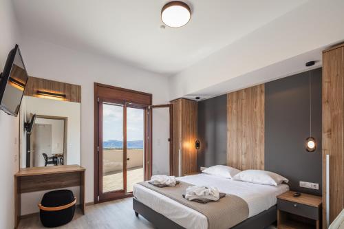 1 dormitorio con 1 cama grande y espejo en Suites Olive Tree Farm Episkopi Village, en Episkopí- Rethimno