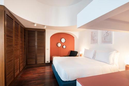 a bedroom with a large white bed and wooden floors at RELSTAY - Montenapoleone Suite in Milan