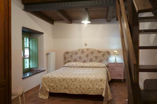 een slaapkamer met een bed, een stoel en een raam bij Agriturismo Al Castagno in Abetone