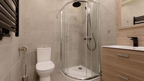 a bathroom with a shower and a toilet and a sink at VacationClub - Apartamenty Zakopiańskie Apartament 222 in Zakopane