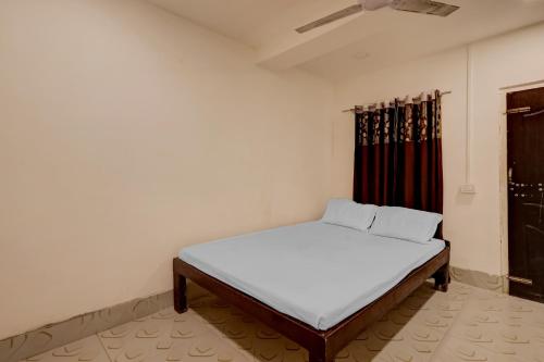 ein weißes Bett in einem Zimmer mit Fenster in der Unterkunft SPOT ON Hotel Paradise Inn in Nowgong