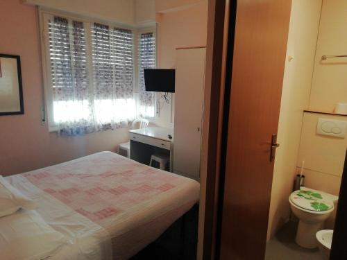 a small bathroom with a bed and a sink at HOTEL GIORDANA in Loano