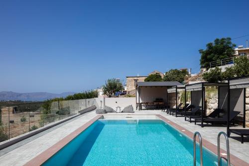 a swimming pool with a view of a house at Suites Olive Tree Farm Episkopi Village in Episkopí- Rethimno