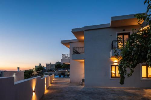 a view of a house with the sunset in the background at Suites Olive Tree Farm Episkopi Village in Episkopí- Rethimno