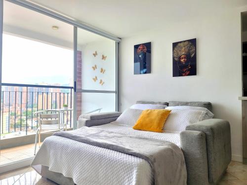 1 dormitorio con cama y ventana grande en Modern High-Rise 2/2 Apartment with City View., en Sabaneta