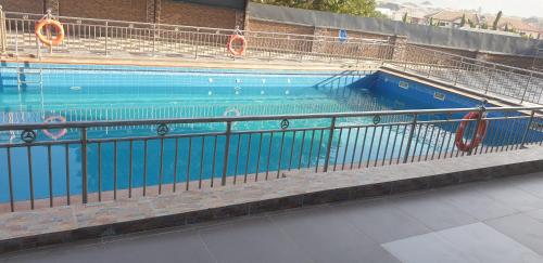 una gran piscina azul con gente en ella en Davina Hill resort & hotel en Gwarinpa