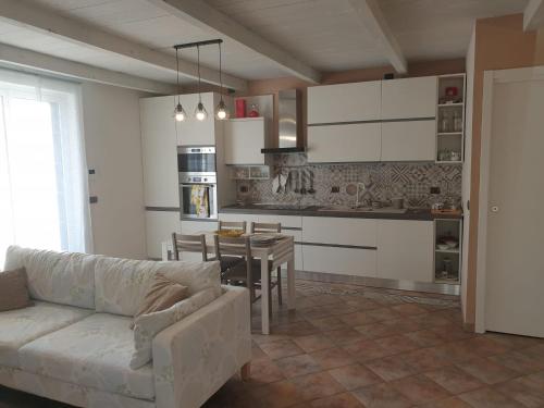 a living room with a couch and a table in a kitchen at Casa Vacanze Alice e Arianna in Cairo Montenotte