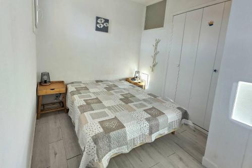 une petite chambre avec un lit et une table de chevet dans l'établissement Rich, à Valras-Plage