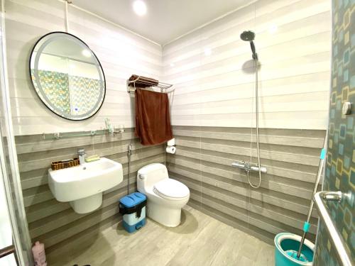 ein Badezimmer mit einem Waschbecken, einem WC und einem Spiegel in der Unterkunft Old town Duplex 3 Double beds & 2 big balcony in Hanoi