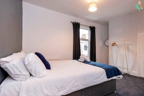 een slaapkamer met een groot wit bed en een raam bij Everett House in Hartlepool