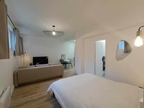 a white bedroom with a bed and a couch at JEAN JAURES in Dijon
