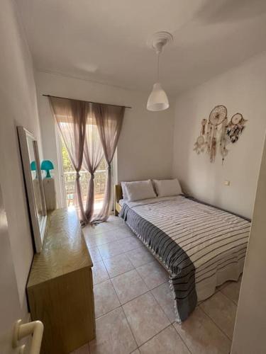 um quarto com uma cama e uma janela em Elena’s apartment em Áyios Vasílios