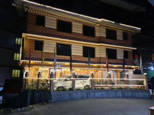 a building with a car parked in front of it at Hotel Zingkham Residency in Gangtok