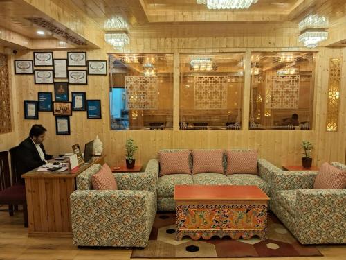 a man sitting at a desk in a waiting room at Hotel Zingkham Residency in Gangtok