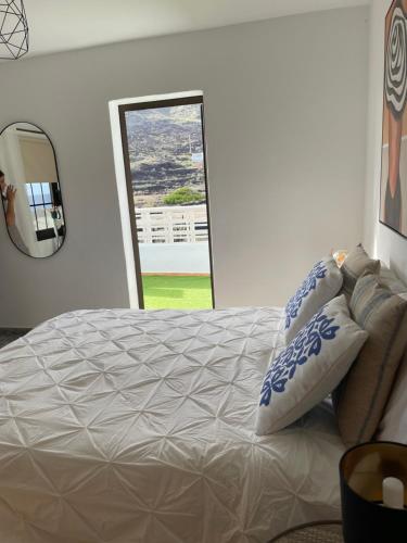 1 dormitorio con cama, espejo y ventana en APARTAMENTO ROSALIA en Timijiraque