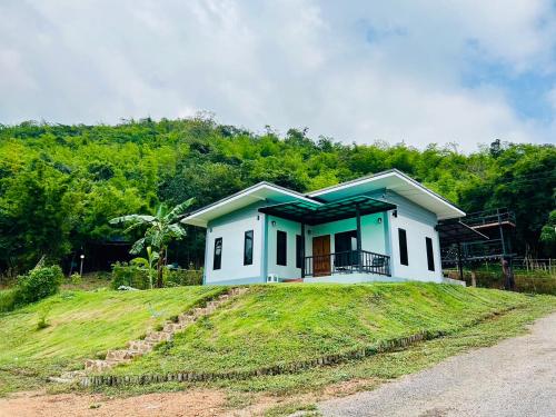 uma pequena casa no topo de uma colina relvada em La Villas@Suanphueng em Ban Bo Wi