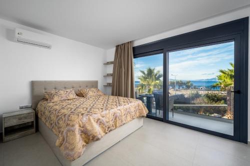 sypialnia z łóżkiem i dużym oknem w obiekcie Penélope Beachfront Villa w mieście Kremasti