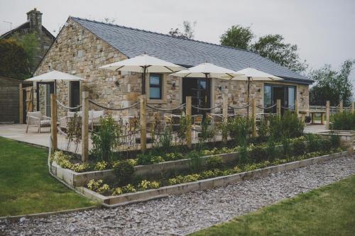 a garden with umbrellas in front of a building at Everything Retreat in Mellor