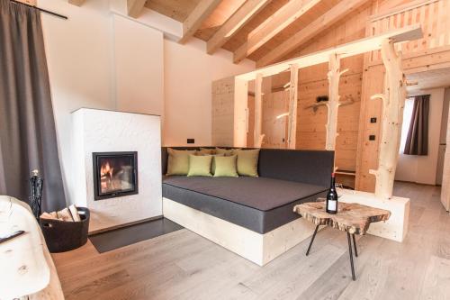 - un salon avec un lit et une cheminée dans l'établissement Chalet Berg, à Selva dei Molini