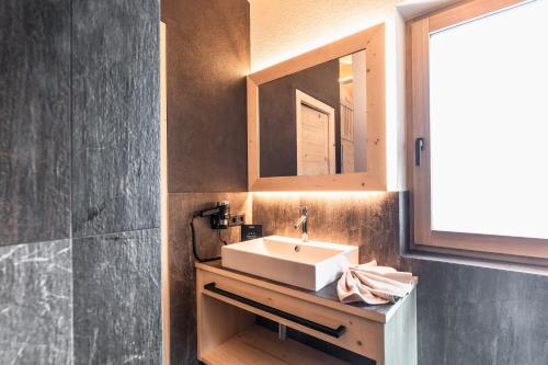 a bathroom with a sink and a mirror at Chalet Berg in Selva dei Molini