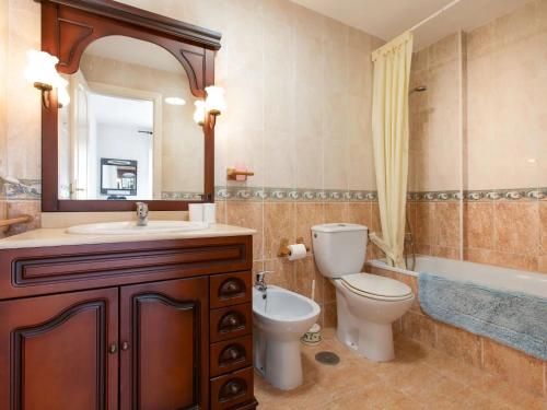 a bathroom with a toilet and a sink and a mirror at Casa del Sol in Salobreña