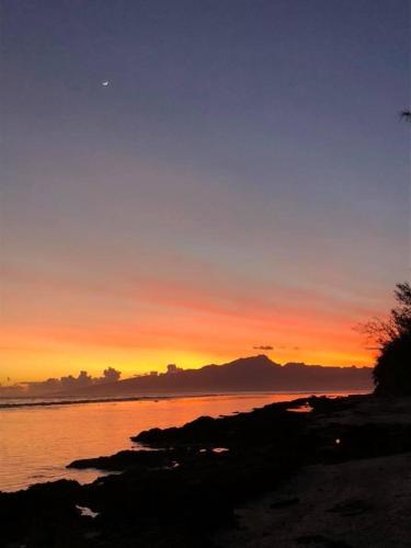 a sunset over a body of water with the sky at Bungalow TEIPO in Teavaro