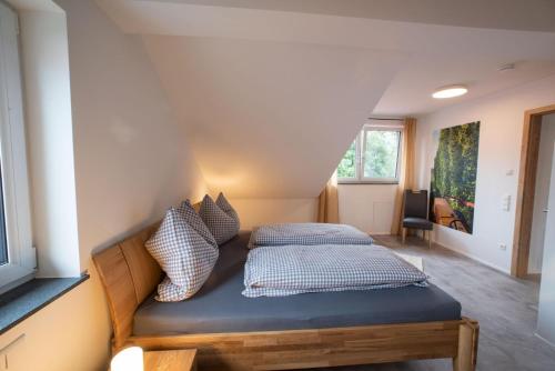 Un dormitorio con una cama con almohadas. en Ferienhof Hopfgärtle Müller, en Bodnegg