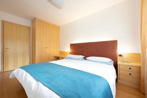 a bedroom with a large bed with a blue blanket at Cesa Delba in Canazei