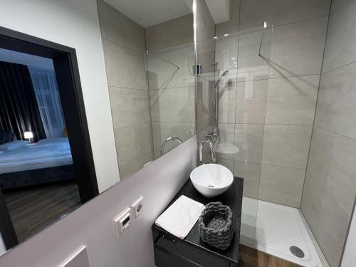 a white bathroom with a sink and a shower at Hotel Elisei in Nürnberg