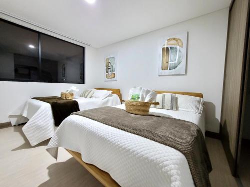 a hotel room with two beds and a large window at New Luxury 3 Bedroom Apartment in Great Area. in Medellín