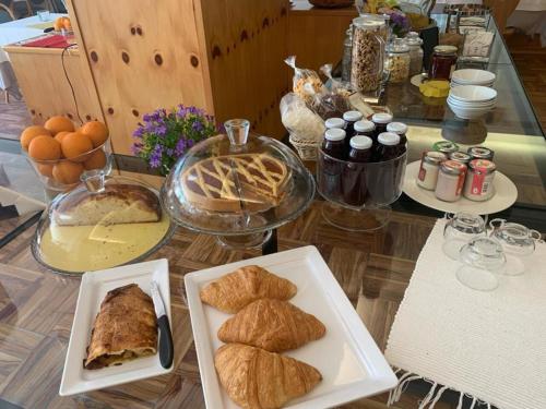 a table topped with plates of pastries and other foods at Hotel Posta in Aprica