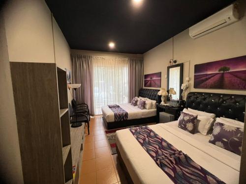 a hotel room with two beds and a living room at Ghazrins Garuda Hotel in Johor Bahru
